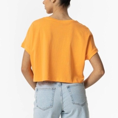 Pessoa de costas com t-shirt laranja e calções de ganga azul claro