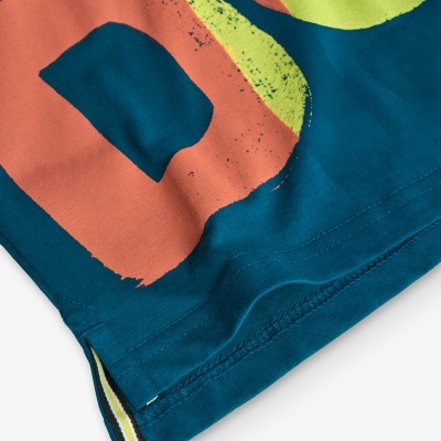 Tecido com padrão gráfico em azul, laranja e amarelo com costura visível