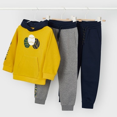 Conjunto infantil amarelo com capuz e duas calças cinza e azul-marinho penduradas