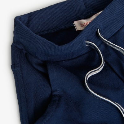 Calças de malha azul escuro com cordão branco e azul escuro.