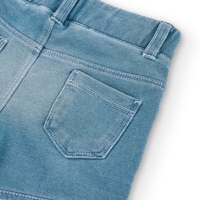 Parte traseira de peça de vestuário denim azul claro com bolso quadrangular