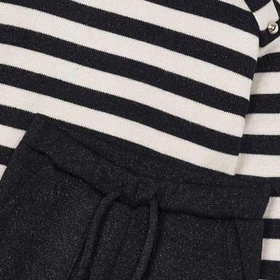 Roupa com riscas pretas e brancas e calça preta com cordão