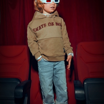 Criança com óculos 3D e camisola castanha num cinema