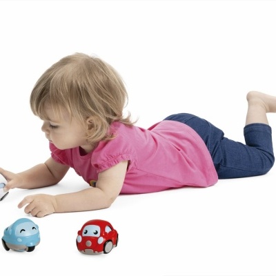 Criança a brincar com carrinhos de brinquedo coloridos