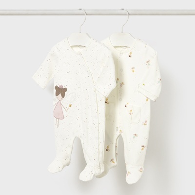 Dois macacões brancos para bebé com desenhos e padrões castanhos e rosa pendurados em cabides.