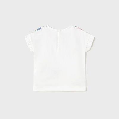 T-shirt branca com folhos e fecho de botão no fundo cinzento