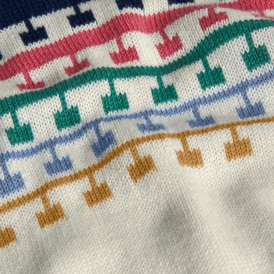 Pano branco de malha com padrão geométrico a cores