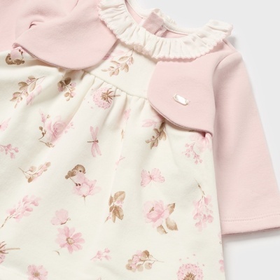 Vestido de bebé com padrão floral e de fadas, mangas cor-de-rosa e gola com folhos brancos.