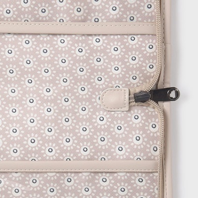 Detalhe de tecido bege com padrão de círculos e zíper preto