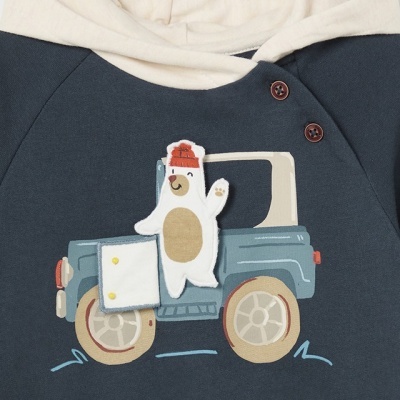 Parte superior de roupa infantil azul com capuz bege e aplicação de urso em carro.