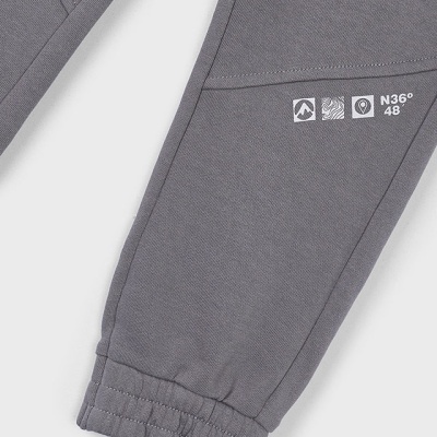 Calças cinzentas com bainha elástica e estampagem branca perto do tornozelo