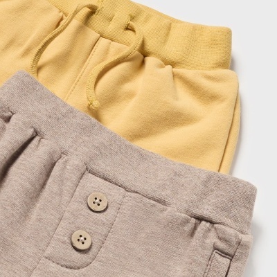 Dois calções infantis em tecidos amarelo e cinza com detalhes de cordão e botões.