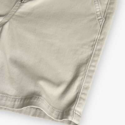 Calça ou calção bege claro em tecido com costuras e bolsos