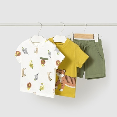 Conjunto infantil com duas t-shirts e calções verdes pendurados.