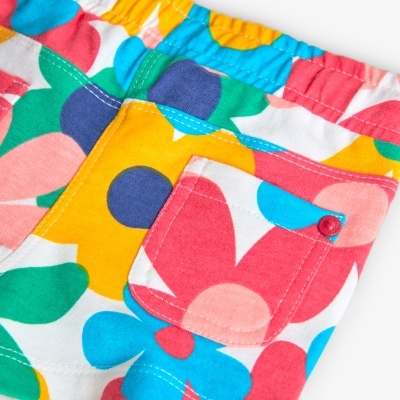 Calções coloridos com padrão floral e bolso traseiro com botão vermelho