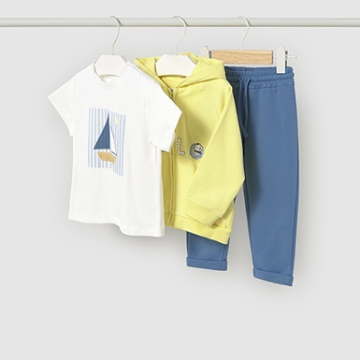 Conjunto infantil com t-shirt branca, casaco amarelo e calças azul-acinzentadas pendurados