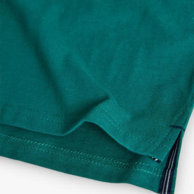 Detalhe de tecido verde com costura dupla e abertura lateral com bordas azul escuro e branco