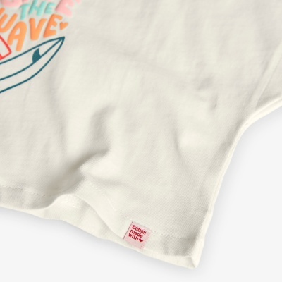 Parte inferior de t-shirt branca com etiqueta vermelha e estampado colorido