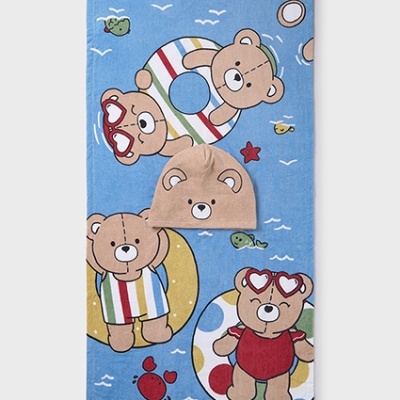 Toalha azul com padrão de ursos e touca bege com rosto de urso bordado