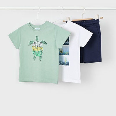 Conjunto de roupa infantil com t-shirts verde e branca e calções azul escuro pendurados
