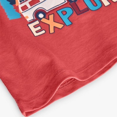 Parte da t-shirt vermelha com estampa colorida e costura dupla na barra