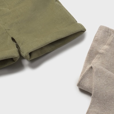 Parte de calções verdes e peça bege em tecido de algodão sobre fundo branco