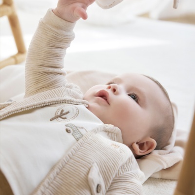 Bebé deitado a alcançar móbil de coração