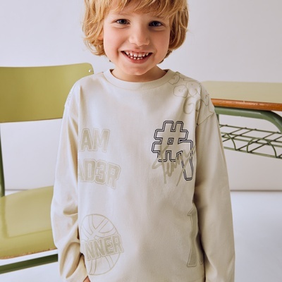 Camisola creme com estampados e criança sorridente