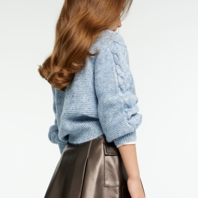 Camisola azul de malha com saia preta brilhante vista de costas