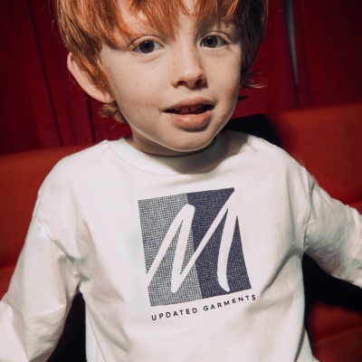 Camisola branca de criança com logótipo preto e branco, em fundo vermelho