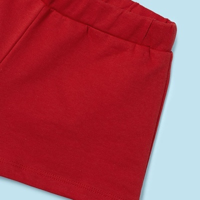 Peça de roupa vermelha com elástico na cintura sobre fundo azul claro