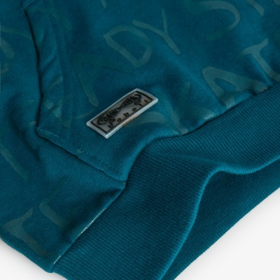 Peça de vestuário azul-escuro com letras e etiqueta retangular na parte inferior