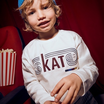 Camisola branca com estampado SKAT usada por criança com gorro azul