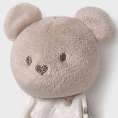 Pelúcia de urso bege com tecido macio e padrão de bolinhas