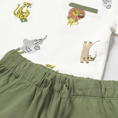 Conjunto de roupa de bebé com camisola branca estampada e calças verdes.