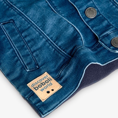 jaqueta de ganga azul com botões metálicos e etiqueta textil