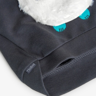 Detalhe de peça de roupa cinzenta escura com etiqueta 'boboli' e detalhes bordados