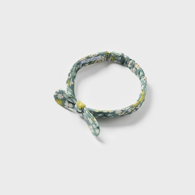 Auricular de tecido azul com padrão floral e nó decorativo