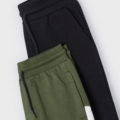 Duas calças caneladas, preta e verde com detalhe branco, sobre fundo branco