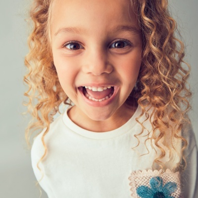 Camisola branca com bolso de renda e flor azul para criança.
