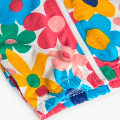 Peça de roupa com padrão floral colorido e fecho de correr branco