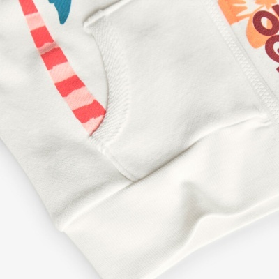 pormenor de peça de roupa branca com bolso e estampas coloridas