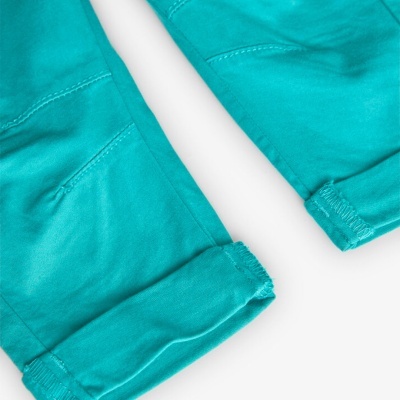 Parte inferior de calças azul-turquesa com bainha dobrada