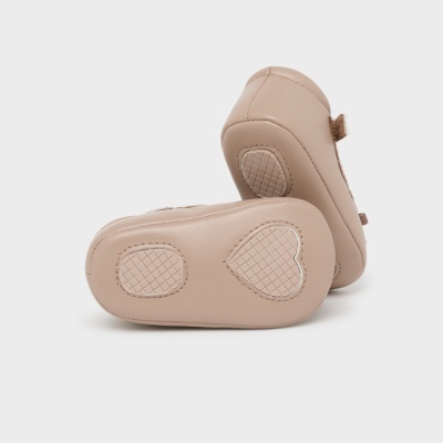 Par de sapatinhos de bebé bege com sola antiderrapante e padrão quadriculado.