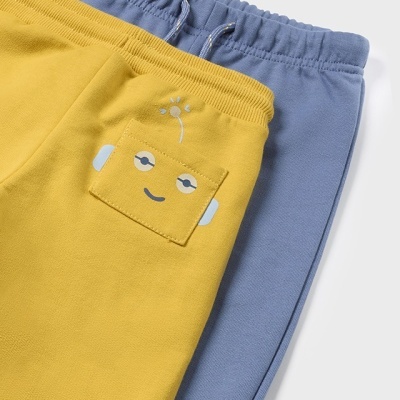 Dois pares de calças felpudas, uma amarela com rosto decorativo no bolso e outra azul com cordão na cintura