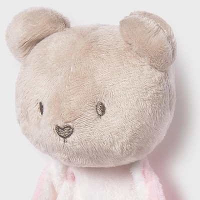 Ursinho de peluche bege e branco com detalhes rosa
