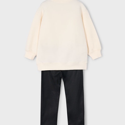 Conjunto de roupa bege e preta visto de costas