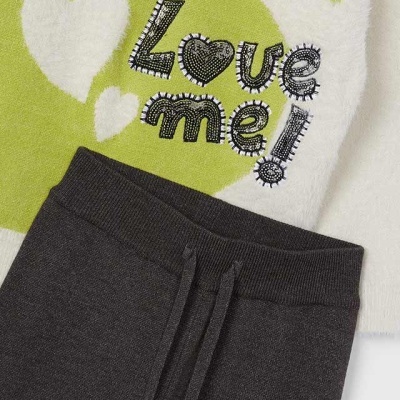 Conjunto de roupa com parte superior felpuda branca e verde com texto Love me! e calças cinzentas escuras com cordão