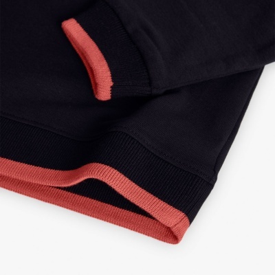 Roupa de malha preta com detalhes em coral nas extremidades em fundo branco