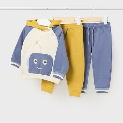 Conjunto de roupa de criança com casaco creme e azul com desenho de robô e duas calças, uma amarela e outra azul.